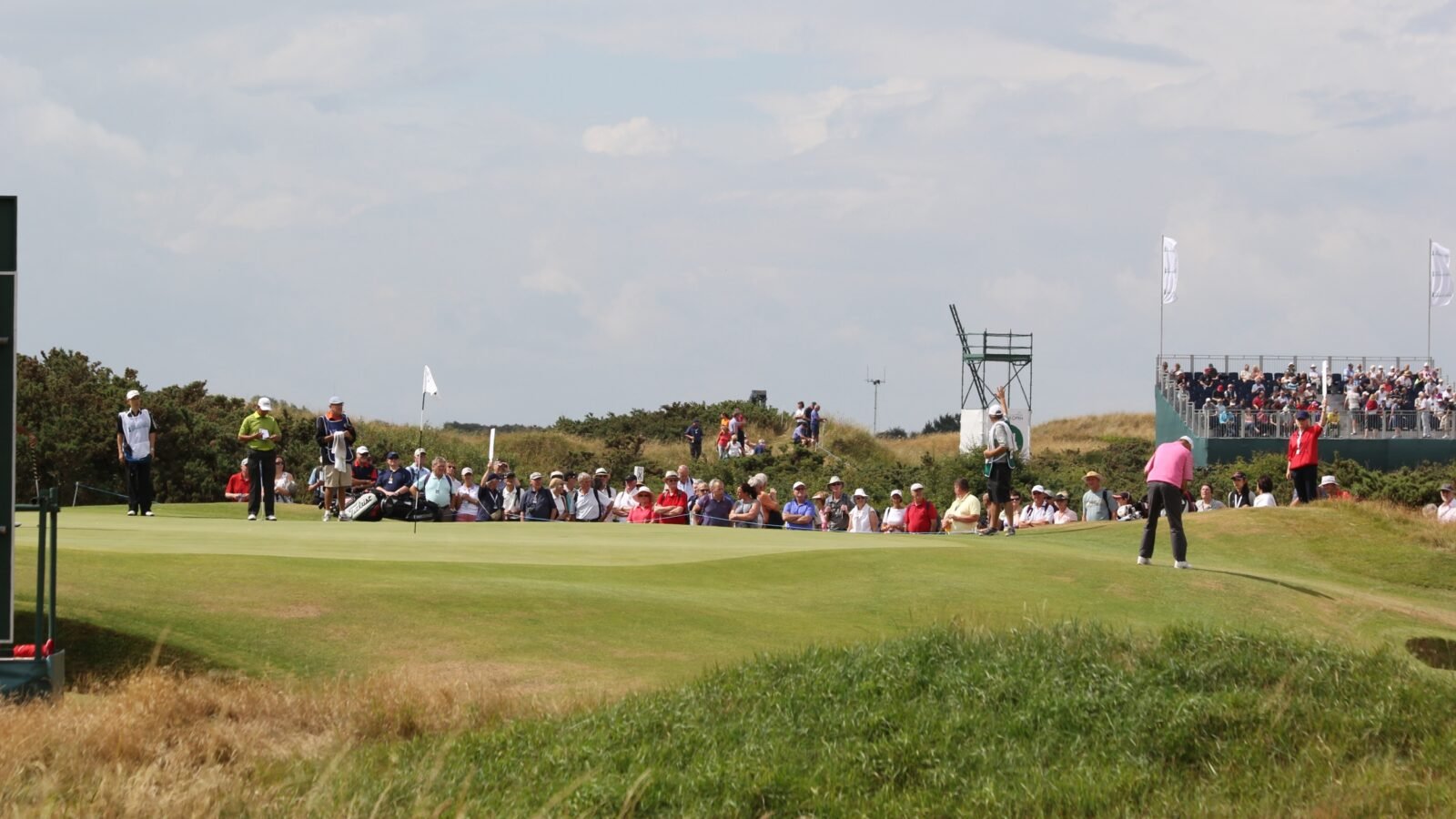 Golfer on the 14th green at Royal Birkdale Golf Club with links dunes behind