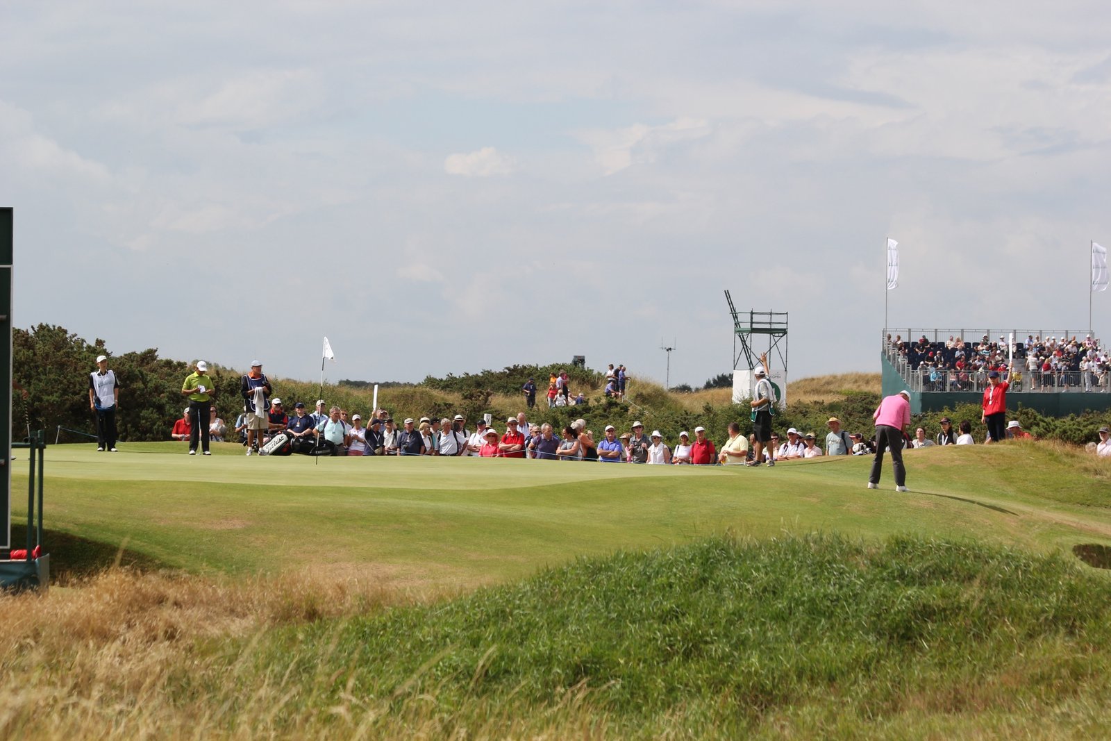 Golfer on the 14th green at Royal Birkdale Golf Club with links dunes behind