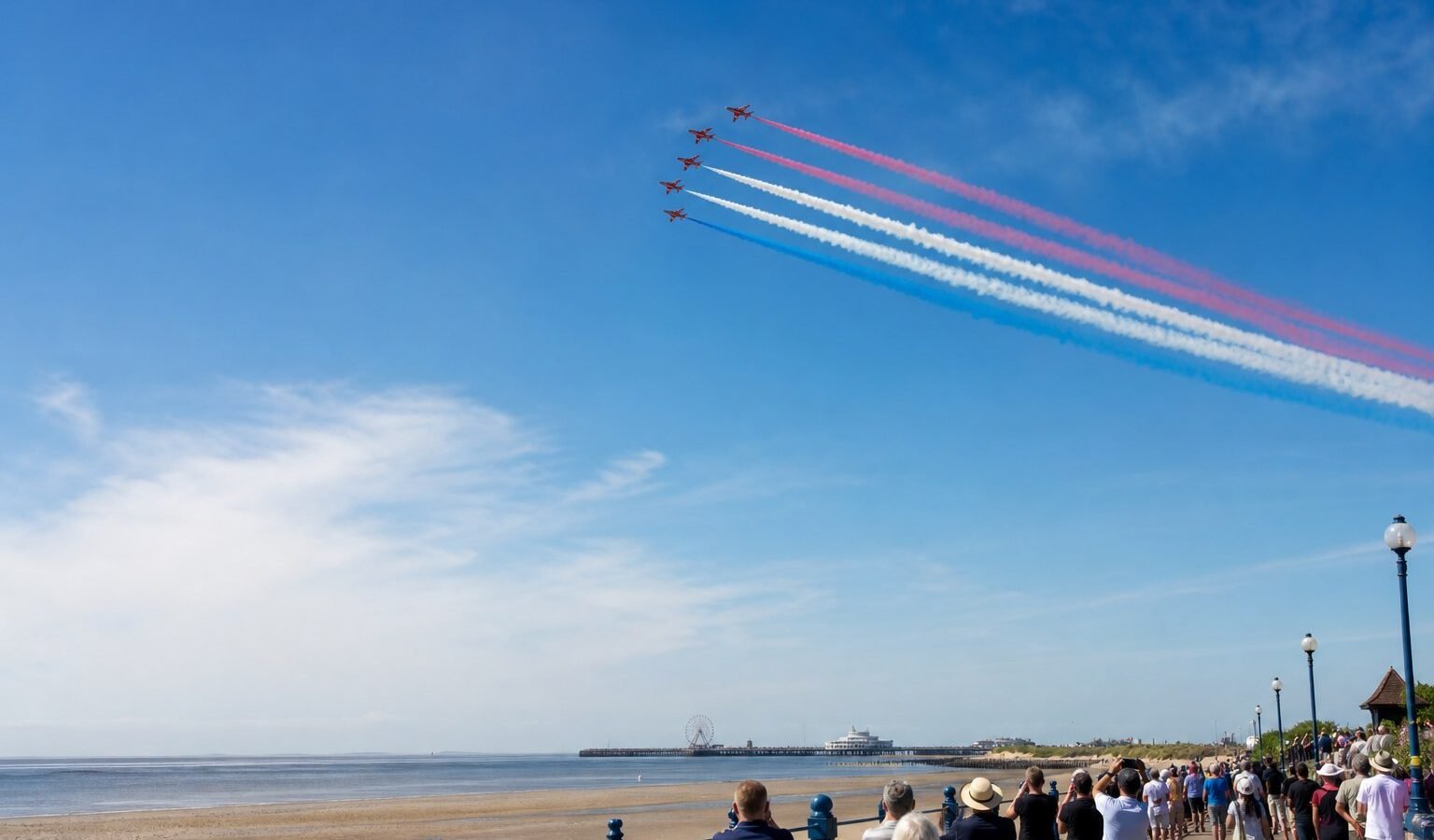 Aerobatic aircraft displaying above a British seaside promenade